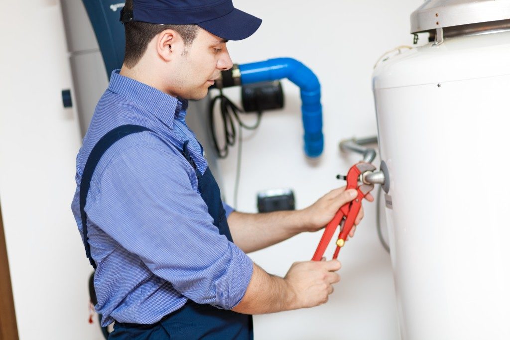 Plumber fixing the water heater