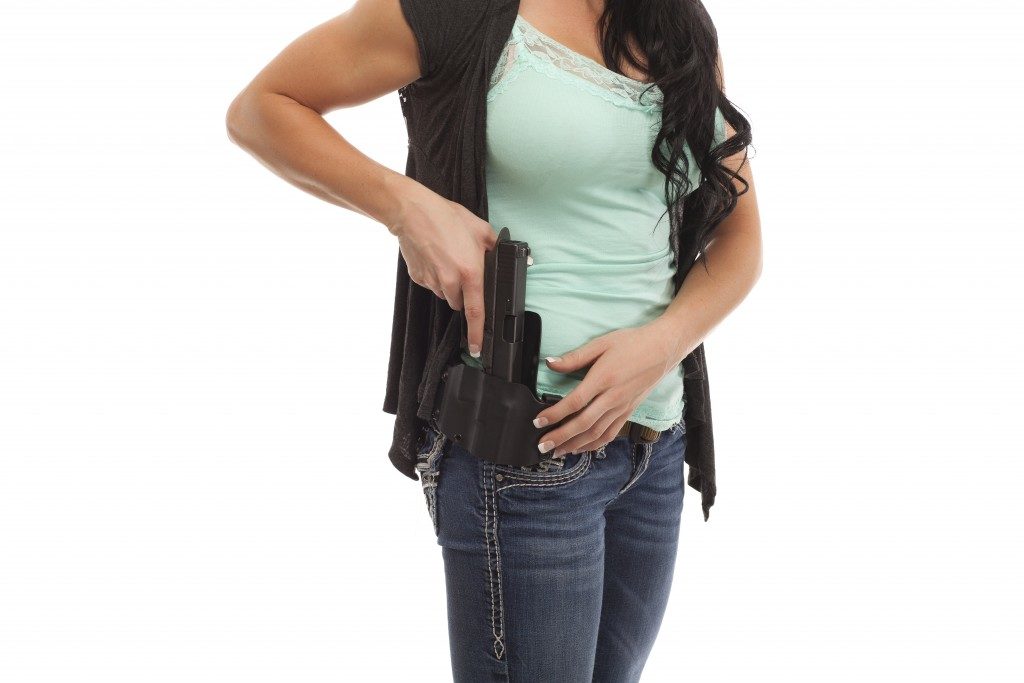 woman drawing handgun from holster