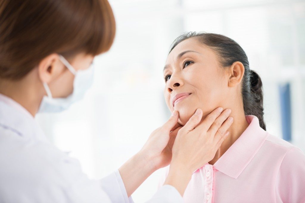 woman checking her thyroid