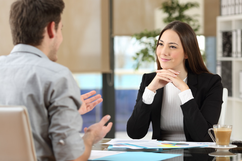 a woman making an effort to listen to a male client as he speaks