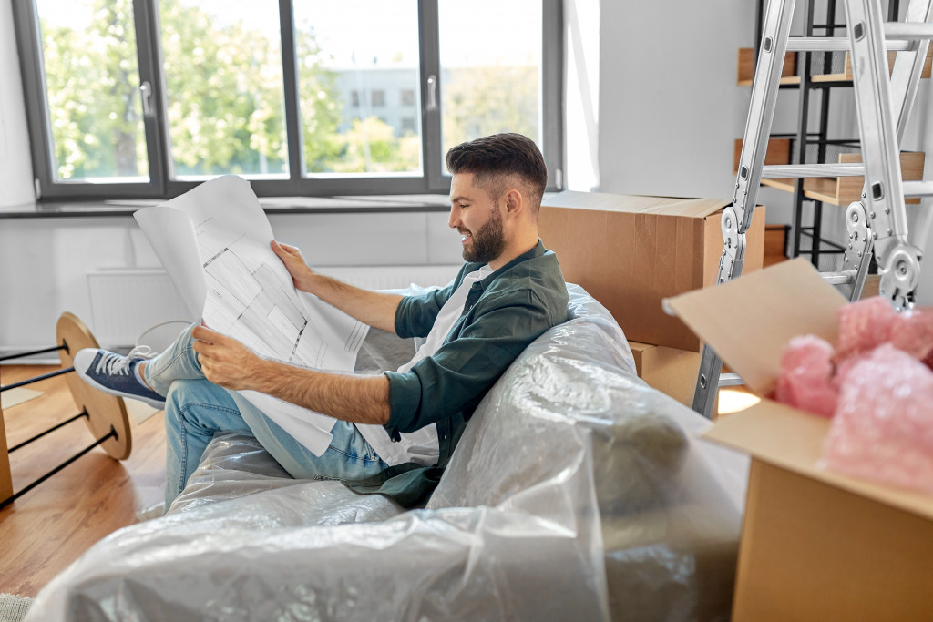 Man consults new house plans to determine where to put his furniture