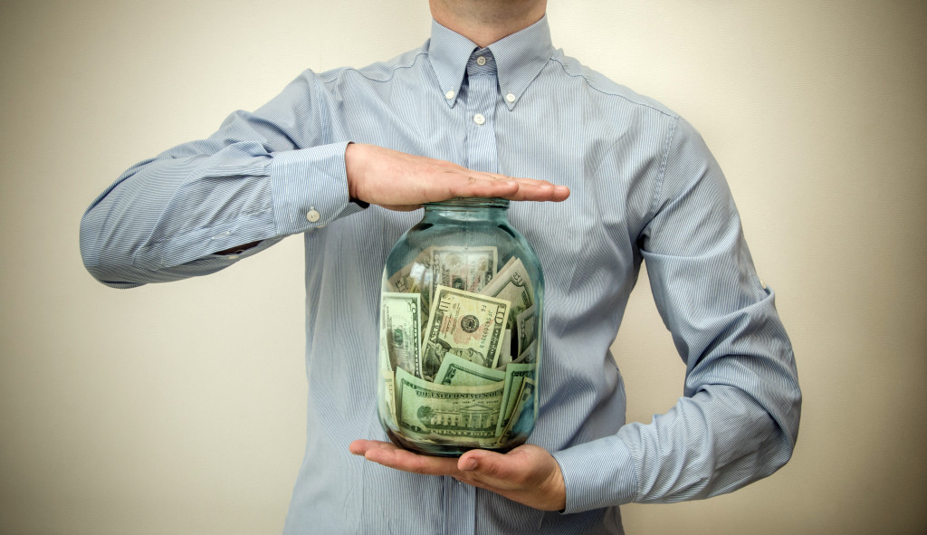 A business owner holding a jar of money